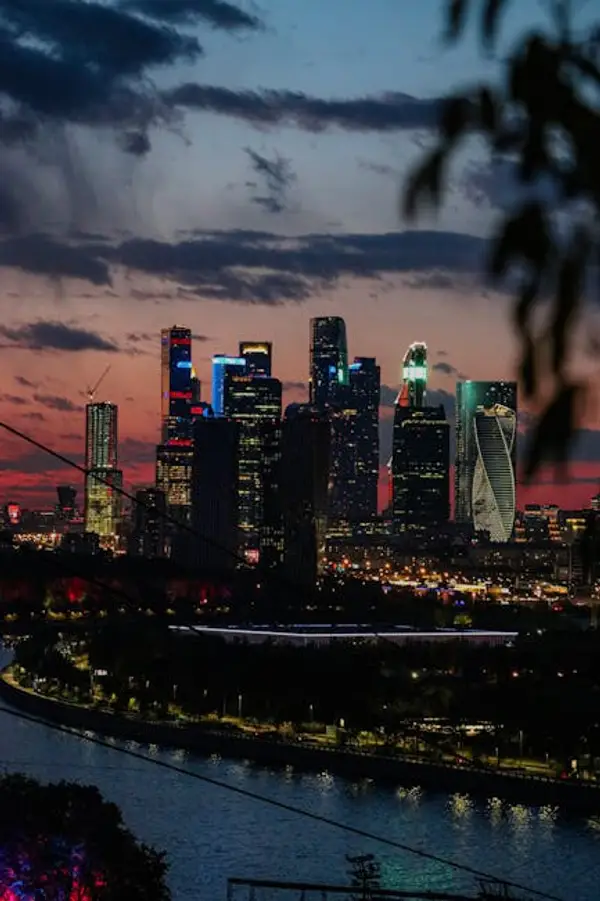 A bustling cityscape with towering skyscrapers under a blue sky
