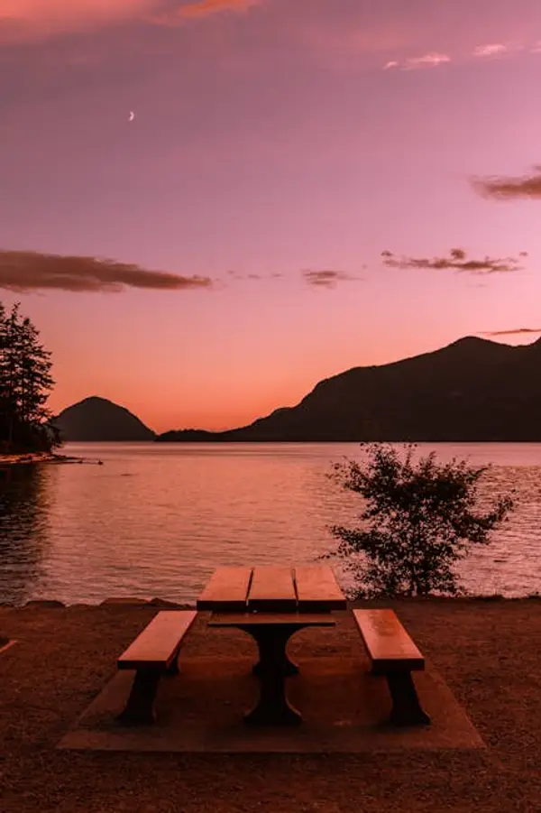 A peaceful sunset over a mountain lake reflecting the sky